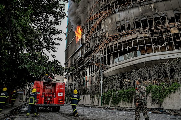 Nepali army personnel and firefighters outside the Hilton Kathmandu hotel after it was burned during days of riots and political upheaval.