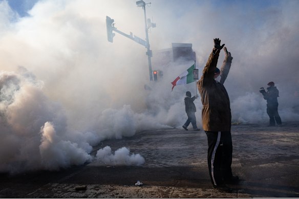 A person holds up their hands as law enforcement deploys a thick screen of tear gas on Nicollet Avenue in Minneapolis on Saturday.
