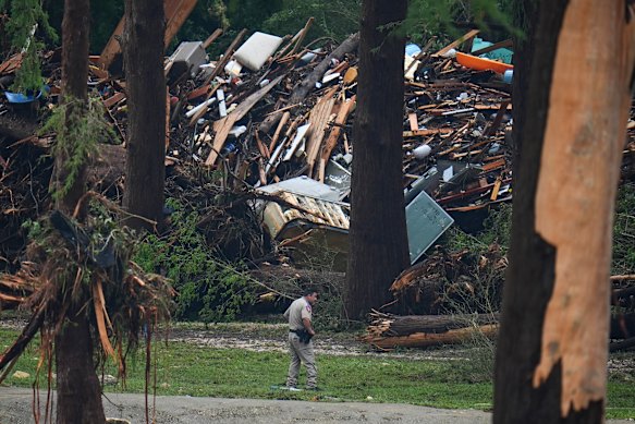 Officials comb through the banks of the Guadalupe River after a flash flood swept through the area.