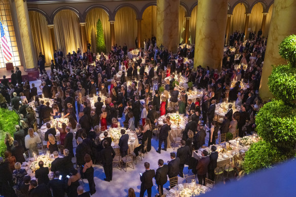 Attendees listen to President-elect Donald Trump speak during a candlelight dinner at the National Building Museum in Washington.
