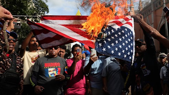 Supporters of ousted Venezuelan President Nicolás Maduro burn a US flag in Caracas.