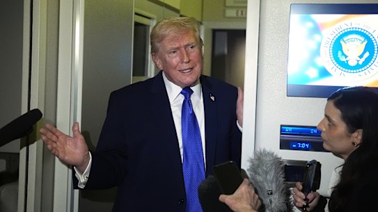 President Donald Trump answers questions on Air Force One.
