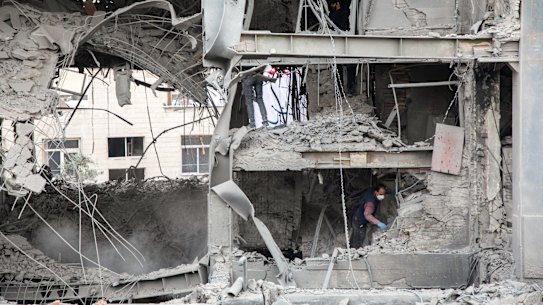 People work in the rubble of a building hit by a US-Israeli strike on a commercial district on March 29, 2026 in Tehran, Iran.