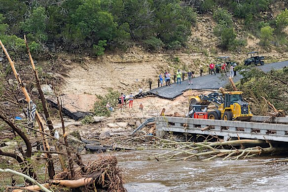 Crews work to clear debris from the Cade Loop bridge along the Guadalupe River on the weekend.