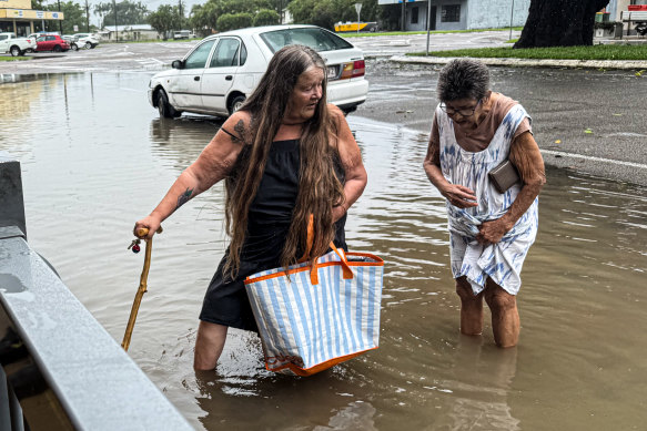 Women cross a flooded street to get food in Halifax.