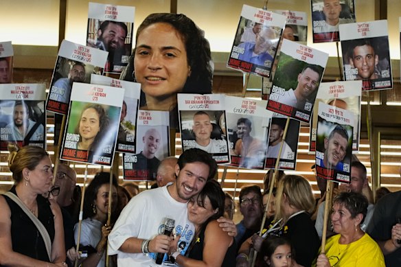 Relatives and supporters of Israeli hostages held by Hamas in the Gaza Strip hold posters with portraits of their loved ones Hostages Square in Tel Aviv.