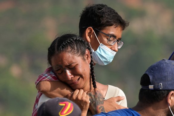 Yolimar Torres, left, cries after she and other family members found her daughter's body, which they recovered themselves from the rubble of a building collapsed by the earthquake in La Guaira, Venezuela.