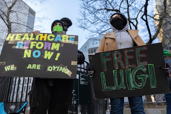 Luigi Mangione’s supporters hold signs outside the Supreme Court in New York.