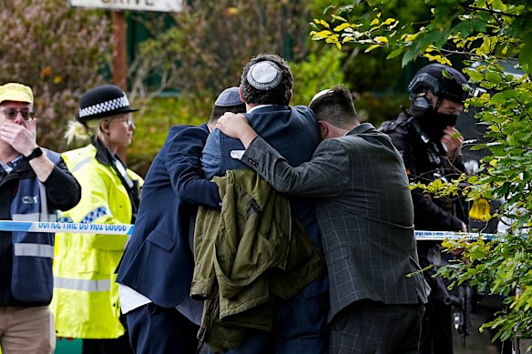 Members of the Jewish community comfort each other near to the Heaton Park Hebrew Congregation synagogue, in Crumpsall, Manchester,  after police reported that two people were killed and three others were seriously injured in a synagogue attack in northern England. 