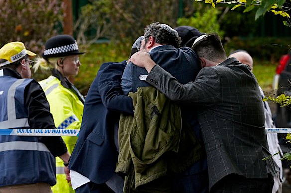 Members of the Jewish community comfort each other near to the Heaton Park Hebrew Congregation synagogue in Manchester after an antisemitic attack.