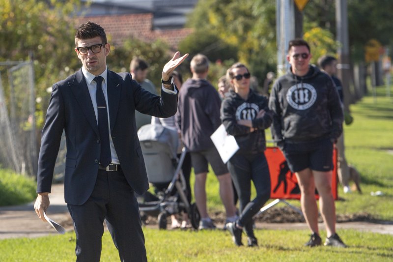Auctioneer Manny Zennelli tries to get more bids at the auction in Benbow Street, Yarraville.