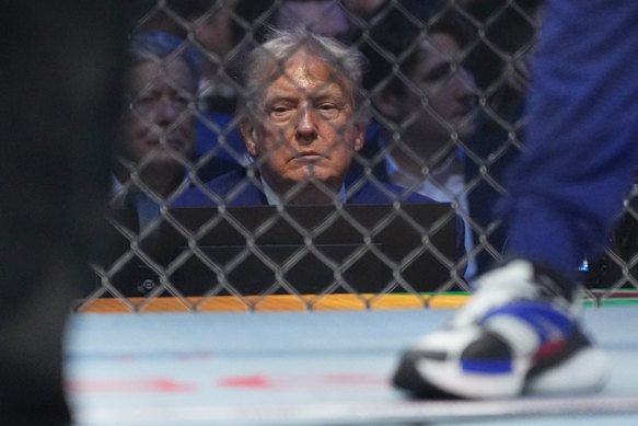President Donald Trump sits ringside.