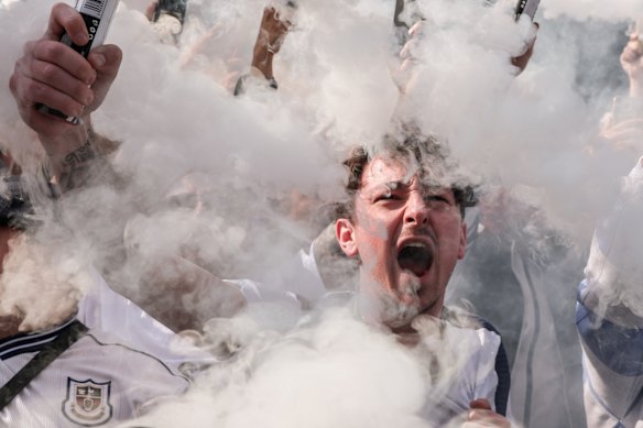 A Tottenham Hotspur supporter sets off a flare as the team bus arrives before the Premier League match between Tottenham Hotspur and Nottingham Forest at Tottenham Hotspur Stadium on March 22, 2026 in London, England. 