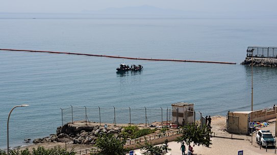 Civil Guard boats patrol alongside floating barriers off the coast of the Spanish enclave of Ceuta.