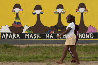 A woman walks past a coronavirus-themed mural promoting the use of face mask in public to protects against COVID-19 in Vereeniging, South Africa.