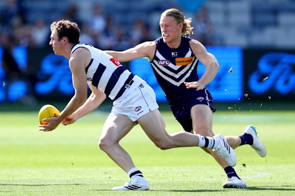 Max Holmes of the Cats is tackled by Hayden Young of the Dockers.