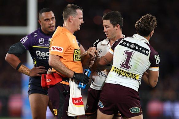 Ben Hunt is held up by Reece Walsh after he was concussed while making a tackle in the grand final. The veteran half was forced from the field late in the game.
