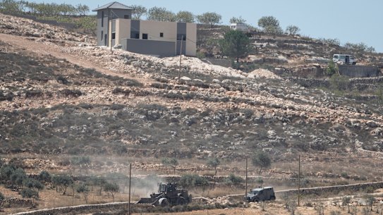 Israeli army vehicles operate near Palestinian houses in the West Bank village of Qusra earlier in August.
