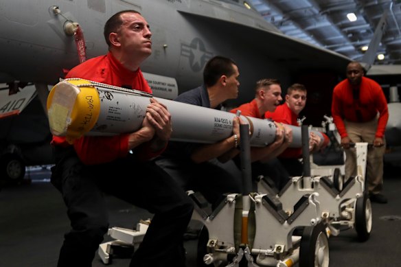 Aviation ordnance men transport a missile aboard the USS Abraham Lincoln. 