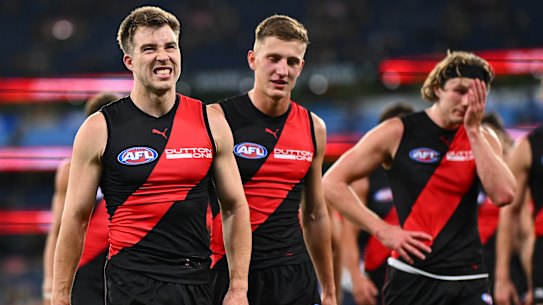 Zach Merrett and the Bombers leave the field after the loss against the Hawks.