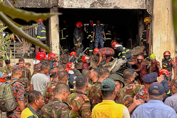 Firemen check the wreckage of a Bangladesh Air Force training aircraft that crashed onto a school campus in Dhaka, Bangladesh.