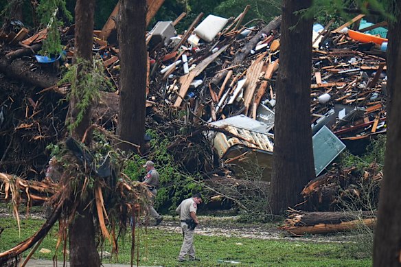 Officials comb through the banks of the Guadalupe River after the weekend’s fatal flash floods.