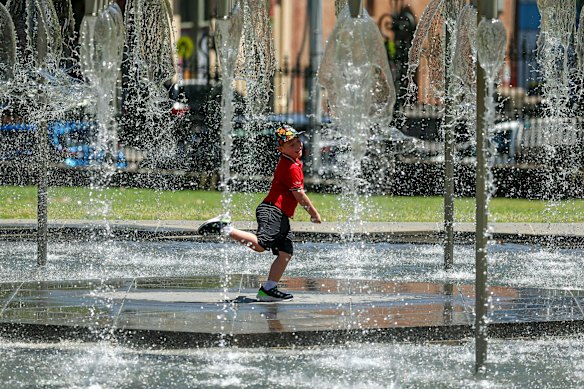 People cooling off in the fountain at Spring Street in Melbourne in late December.