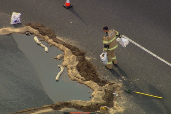 Fire Rescue Victoria officers are cleaning up fuel that was spilled on the freeway. 