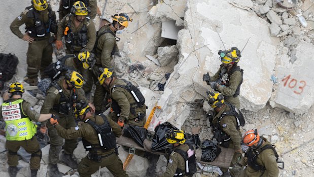 Emergency and rescue soldiers extract a body from rubble after an overnight missile strike from Iran in Bat Yam Israel.