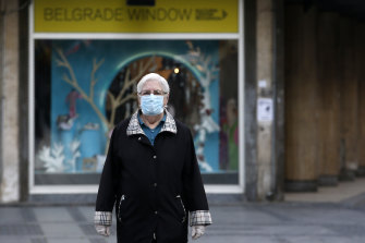 An elderly woman wearing a mask against the spread of the new coronavirus walks during a curfew in downtown Belgrade, Serbia.