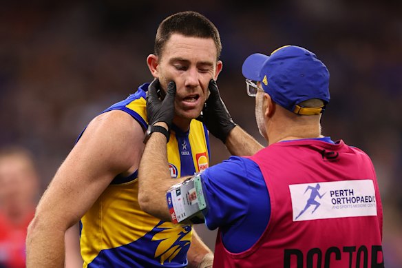 Eagles defender Jeremy McGovern is checked by the club doctor after a collision with the Demons’ Harrison Petty in round eight.