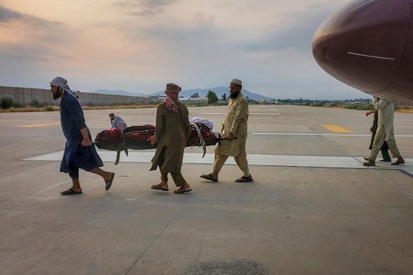 An earthquake victim on a stretcher is carried to an ambulance at an airport in Jalalabad.