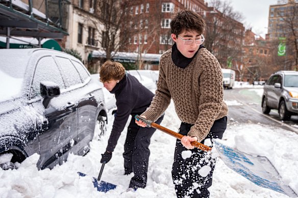 Residents dig out a parked car in Brooklyn, New York.