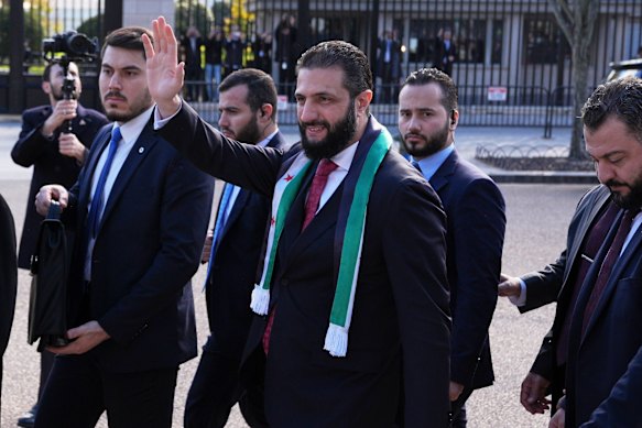 Sharaa waves to supporters outside the White House after his meeting with Trump.