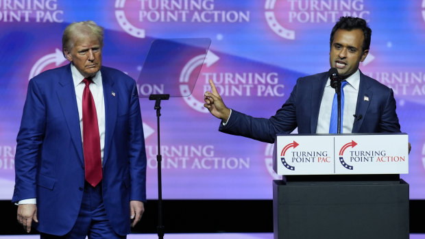 President-Elect Donald Trump listens as Vivek Ramaswamy speaks during a campaign rally in October.