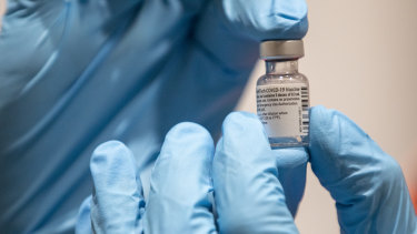 A health worker holds a dose of the Pfizer vaccine.