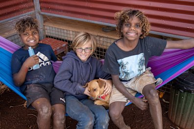 Paul Gosney’s son, Finn, (centre) with Yuendumu locals and Moana in the Northern Territory.