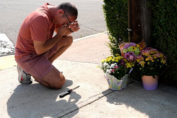 Misael Valdez kneeling at an intersection where the fatal shooting occurred.