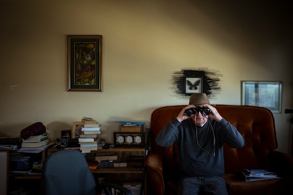 74 year-old Bill McKenzie watches for birds on Albert Park beach from the living room of his home in the public housing towers at 150 Victoria Avenue, Albert Park.