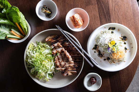 Pork jowl hansang served with cold noodles, lettuce wraps, kimchi and sauce.