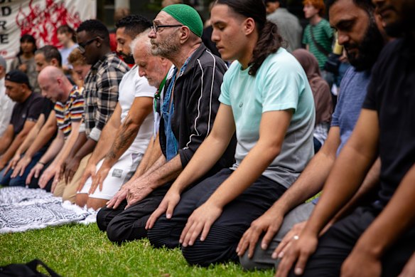 People participate in a prayer outside the Surry Hills Police station on Tuesday in protest against the police action on Monday.