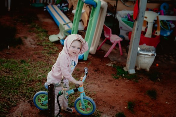 Nova Pearce plays in her backyard in South Broken Hill, as mother Darcy watches on. 