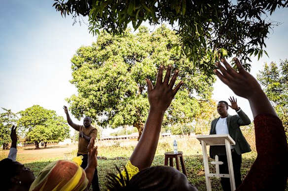  Fred Alimets congregation respond to his sermon under a mango tree. For two weeks Fred held his service outside under the tree as the physical church was re-built after being destroyed by a storm.