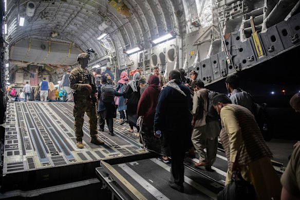 Afghan passengers board a US Air Force plane to leave Kabul on August 22, 2021.
