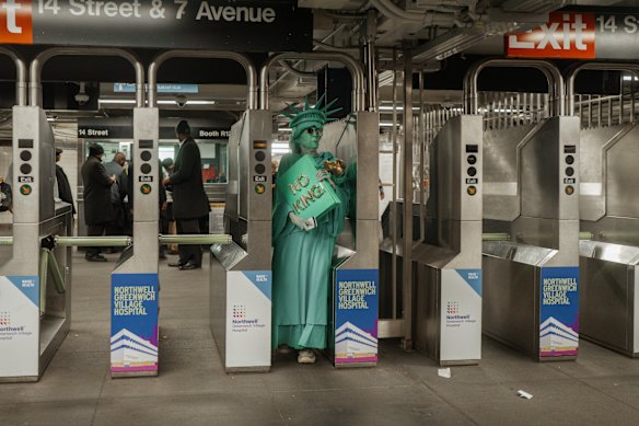 A protester dressed in a Statue of Liberty costume enters a New York subway station after a “No Kings” demonstration in October. 