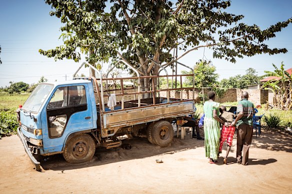 Local Witch doctor Robert Apedu and Florence Aguro carry Florence's son Noah Oyara into the shade after Robert treated Noah. Noah has no use of his legs and also lives with hydrocephalus. Robert treated these conditions by rubbing a paste of water and plant matter into Noahs skin. 