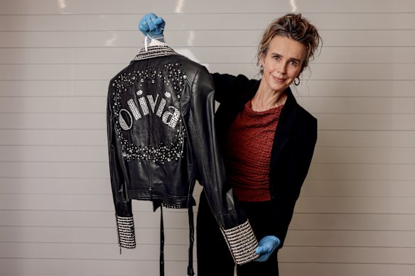 Curator Margot Anderson with a jacket worn by Olivia Newton-John during one of her Vegas residencies.