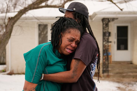 A woman is comforted on the street after immigration agents broke down the door of a house to arrest one of her relatives on Sunday.