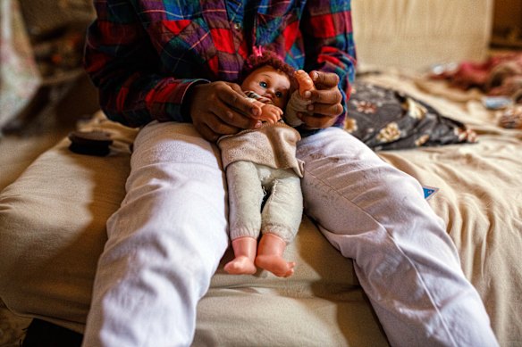 Dalia plays with a doll her mother found in the rubbish.