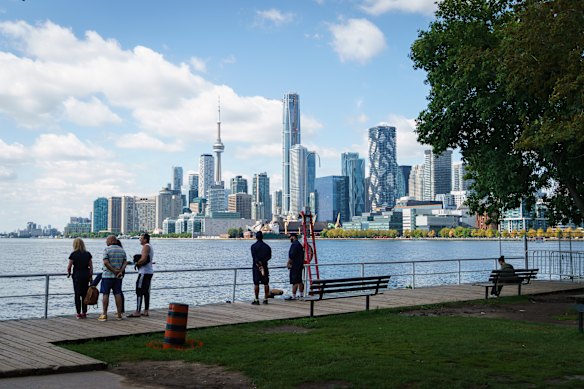 People look out across Lake Ontario from the harbour in Toronto, Canada.